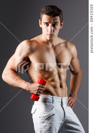 pain relief, sport, bodybuilding, strength and people concept - young man standing over black background pain relief, sport, bodybuilding, strength and people concept - young man standing over black background 88419169