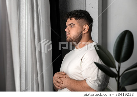 Overweight man suffering from depression at home Overweight man suffering from depression at home 88419238
