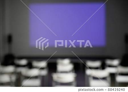 Blurred view of empty conference room with chairs and projector screen 88419240