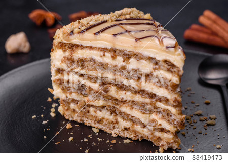 Esterhazy cake sliced on black plate close-up. Delicatessen sweet dessert with almond meringue dough and buttercream Esterhazy cake sliced on black plate close-up. Delicatessen sweet dessert with almond meringue dough and buttercream 88419473