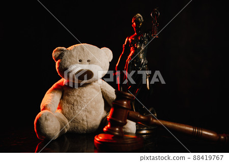 Judge gavel, figure of lady of justice and teddy bear in a dark court room. Law protection and children concept Judge gavel, figure of lady of justice and teddy bear in a dark court room. Law protection and children concept 88419767