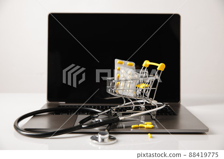 Concept for online trade and sales of medicines and vitamins. Small trolley with medicines Concept for online trade and sales of medicines and vitamins. Small trolley with medicines 88419775