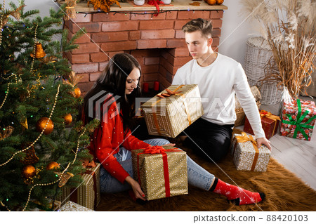 The fianc gives a gift to his beloved on Christmas Day. A unique Christmas atmosphere. A surprise during the holidays. 88420103