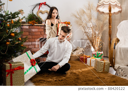 The fianc e gives a gift to her lover on Christmas Day. A unique Christmas atmosphere. A surprise during the holidays. The fianc e gives a gift to her lover on Christmas Day. A unique Christmas atmosphere. A surprise during the holidays. 88420122