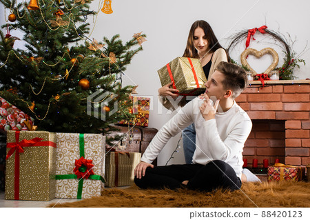 The fianc e gives a gift to her lover on Christmas Day. A unique Christmas atmosphere. A surprise during the holidays. The fianc e gives a gift to her lover on Christmas Day. A unique Christmas atmosphere. A surprise during the holidays. 88420123