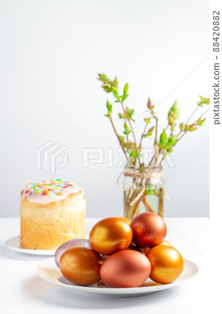 Easter cake with sweet icing and golden eggs on white plate. Easter cake with sweet icing and golden eggs on white plate. 88420882