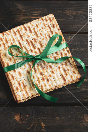 Matzah background. Happy Passover. Traditional Jewish regilious holiday Pesach. Matzo bread on a dark wooden table. Matzah background. Happy Passover. Traditional Jewish regilious holiday Pesach. Matzo bread on a dark wooden table. 88420883