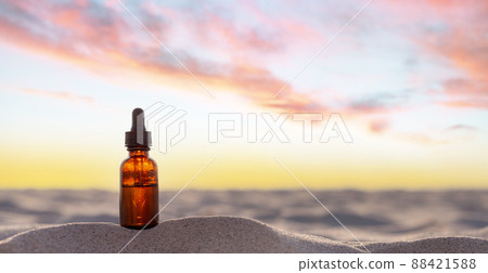 Essential oil bottle on the beach - place for description. 88421588