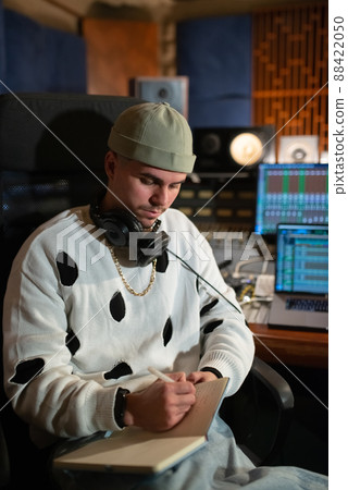Portrait of confident young music producer writing in notepad Portrait of confident young music producer writing in notepad 88422050