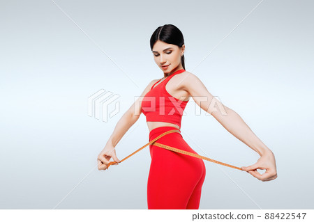 Concept of healthy eating. Fitness woman measuring waist Concept of healthy eating. Fitness woman measuring waist 88422547