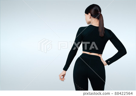Beautiful fit woman in black sport wear standing on white background. Back view Beautiful fit woman in black sport wear standing on white background. Back view 88422564