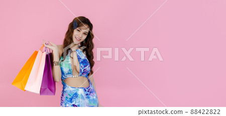 happy beautiful woman wearing summer dress looking at camera holding colorful shopping bags. happy beautiful woman wearing summer dress looking at camera holding colorful shopping bags. 88422822