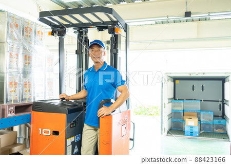 Middle male worker driving a forklift in a warehouse 88423166