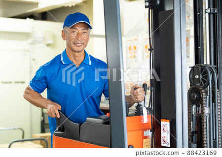 在倉庫裡駕駛叉車的中年男工 88423169
