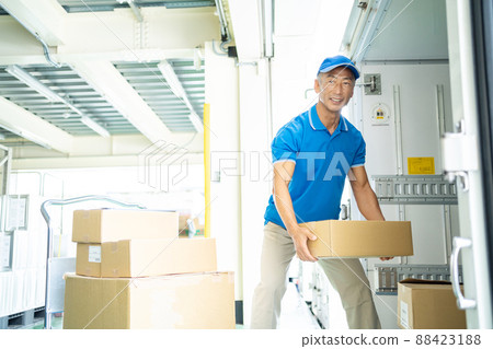 Senior male driver working in a warehouse Senior male driver working in a warehouse 88423188