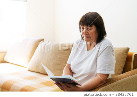 Soothing reading. Portrait of thoughtful elderly woman reading her favorite 88423701