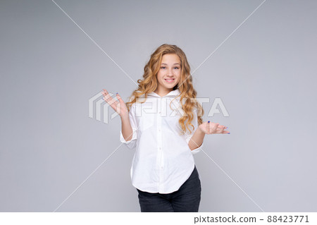 Young caucasian pretty charming blonde woman with wavy hair in white shirt Young caucasian pretty charming blonde woman with wavy hair in white shirt 88423771