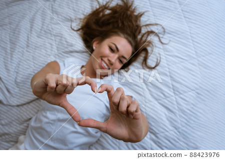 Happy young woman wake up in comfortable white bed 88423976