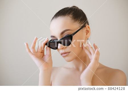 Beauty fashion model girl with brown hair wearing stylish sunglasses touches 88424128