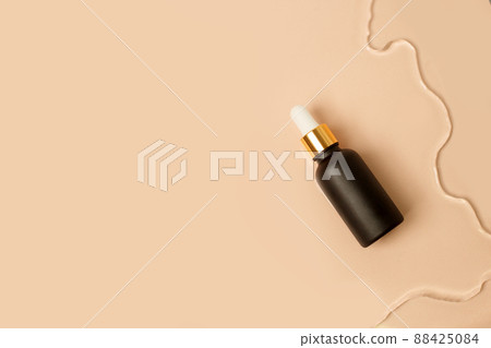 Amber matt glass dropper bottle with white lid in water on beige light background. Skincare products , natural cosmetic. Beauty concept for face and body care 88425084