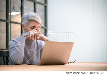 Frustrated mature business woman keeping eyes closed and massaging nose 88426175