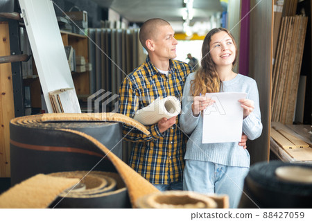 Woman and man discussing shopping list in building store 88427059