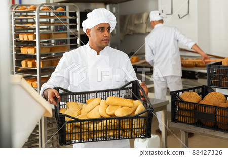 male baker with sesame bread in black box in kitchen 88427326