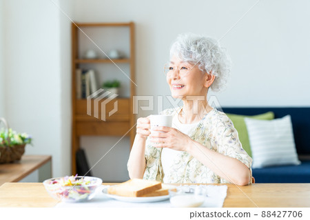 Senior woman eating breakfast Senior woman eating breakfast 88427706