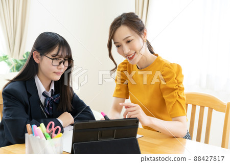 教師和高中女生在使用平板電腦時教授學習 教師和高中女生在使用平板電腦時教授學習 88427817