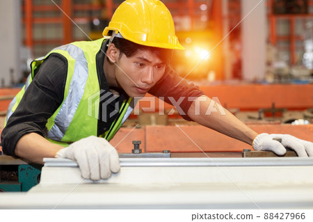 Asian male workers wear red helmet working check up iron production in factory. 88427966