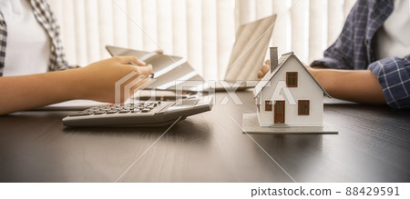 House model with agent and customer discussing for contract to buy, get insurance or loan real estate or property. 88429591