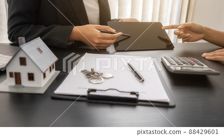 House model with agent and customer discussing for contract to buy, get insurance or loan real estate or property. 88429601