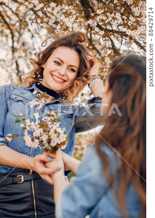 Fashionable mother with daughter. Family in a spring park. Woman in a blue shirt 88429714