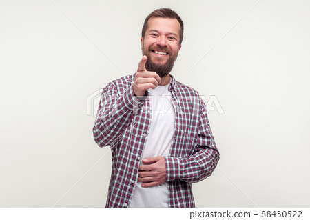Haha, hey you. Portrait of joyful bearded man in plaid shirt pointing finger and holding belly, can't stop laughing, making fun towards friends with rude jokes. studio shot isolated, white background 88430522