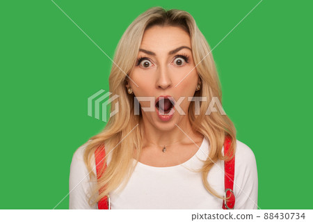 I can't believe this. Closeup portrait of funny amazed adult blond woman standing with wide open mouth and shouting in surprise, shocked expression. indoor studio shot isolated on green background I can't believe this. Closeup portrait of funny amazed adult blond woman standing with wide open mouth and shouting in surprise, shocked expression. indoor studio shot isolated on green background 88430734
