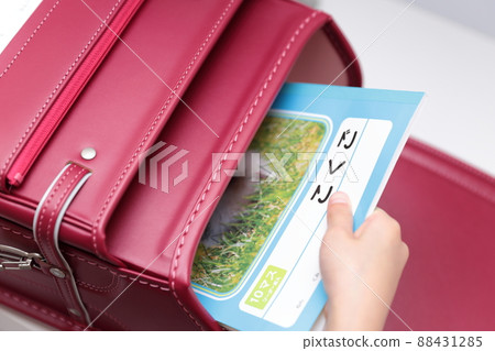 Girl's hand taking out a textbook from a school bag 88431285
