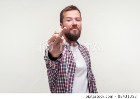 Portrait of impolite bully bearded man in casual plaid shirt showing middle finger fuck off gesture, aggressive hater expressing disrespect, protest. indoor studio shot isolated on white background 88431358