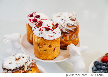 decorated panettones and cruffins on serving plate with rabbits. easter cakes.  88432060