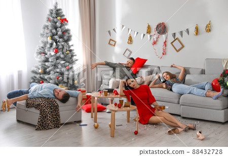 Friends suffering from hangover in messy room after New Year party Friends suffering from hangover in messy room after New Year party 88432728