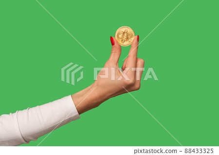 Closeup of woman hand holding golden bitcoin, advertise of digital money btc coin for e-commerce, blockchain technology and cryptocurrency, electronic investment. indoor studio shot, green background 88433325