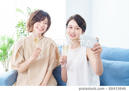 兩個女人手裡拿著香檳酒杯拍照 兩個女人手裡拿著香檳酒杯拍照 88433646