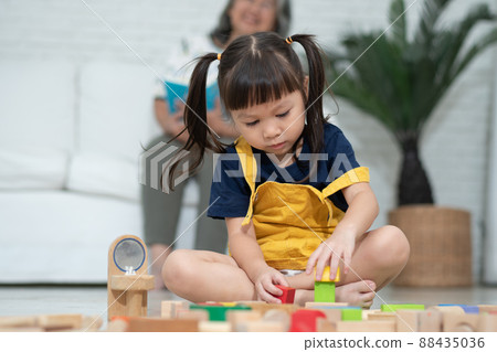 Cute asian little girl playing with colorful toy blocks, Kids play with educational toys at kindergarten or daycare. Creative playing of kid development concept, Toddler kid in nursery. 88435036