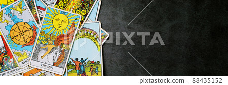 A pile deck of Tarot cards gypsy inspired on a wooden background scattered and haphazardly arranged. Fortune teller, Magician, wizard. Horoscope. 88435152