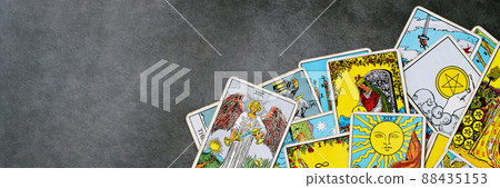 A pile deck of Tarot cards gypsy inspired on a wooden background scattered and haphazardly arranged. Fortune teller, Magician, wizard. Horoscope. 88435153