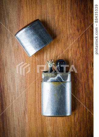 Old vintage lighter on a wooden background Old vintage lighter on a wooden background 88435339