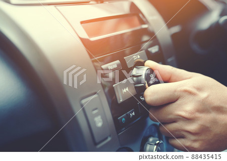 close up hand open car radio listening. Car Driver changing turning button Radio Stations on His Vehicle Multimedia System. Modern touch screen Audio stereo System. transportation and vehicle concept close up hand open car radio listening. Car Driver changing turning button Radio Stations on His Vehicle Multimedia System. Modern touch screen Audio stereo System. transportation and vehicle concept 88435415