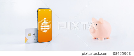 Mobile banking. Smartphone with internet online bank application. Piggy bank with debit card on white background. Save money business concept. 88435968