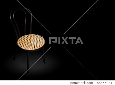 Lonely chair at the empty room. Wooden Chair in spotlight in dark black room. 88436074