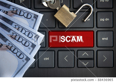 Scam text on red laptop tab with locker and bank notes background. 88436965
