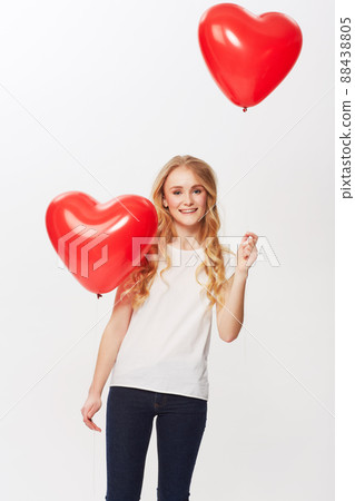 Love is in the air. Cropped view of a young woman holding a red heart in a studio. 88438805